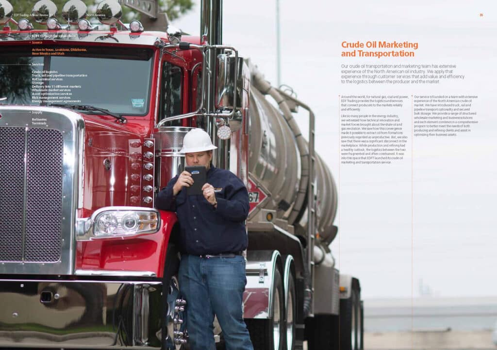 Worker using a tablet beside a red crude oil tanker truck, professionally lit with a large softbox for an energy company’s annual report image.