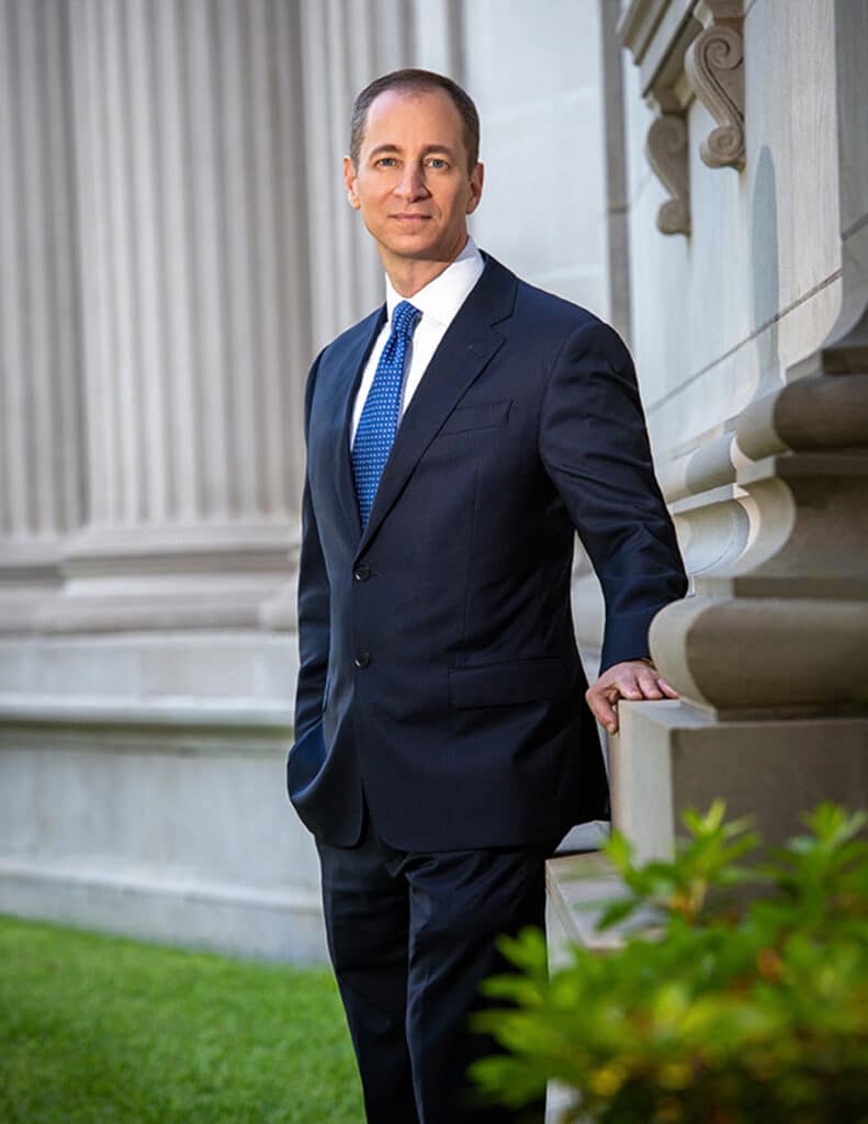 Final retouched executive editorial portrait of Grant Scheiner, incoming President of the Houston Lawyers Association, photographed in Houston in June 2020 with soft off-camera flash from camera left balanced with bright ambient architectural pillars, photographed by Solaris Studios.  bespoke executive portraits Houston