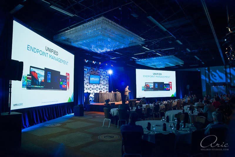 VMware technology conference keynote presentation about unified endpoint management displayed on large screens during a corporate event
