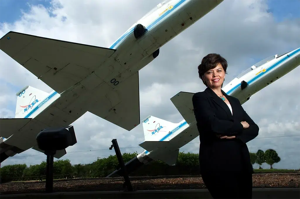 Environmental executive portrait of aerospace professional photographed with dramatic natural lighting beside NASA training aircraft for leadership branding