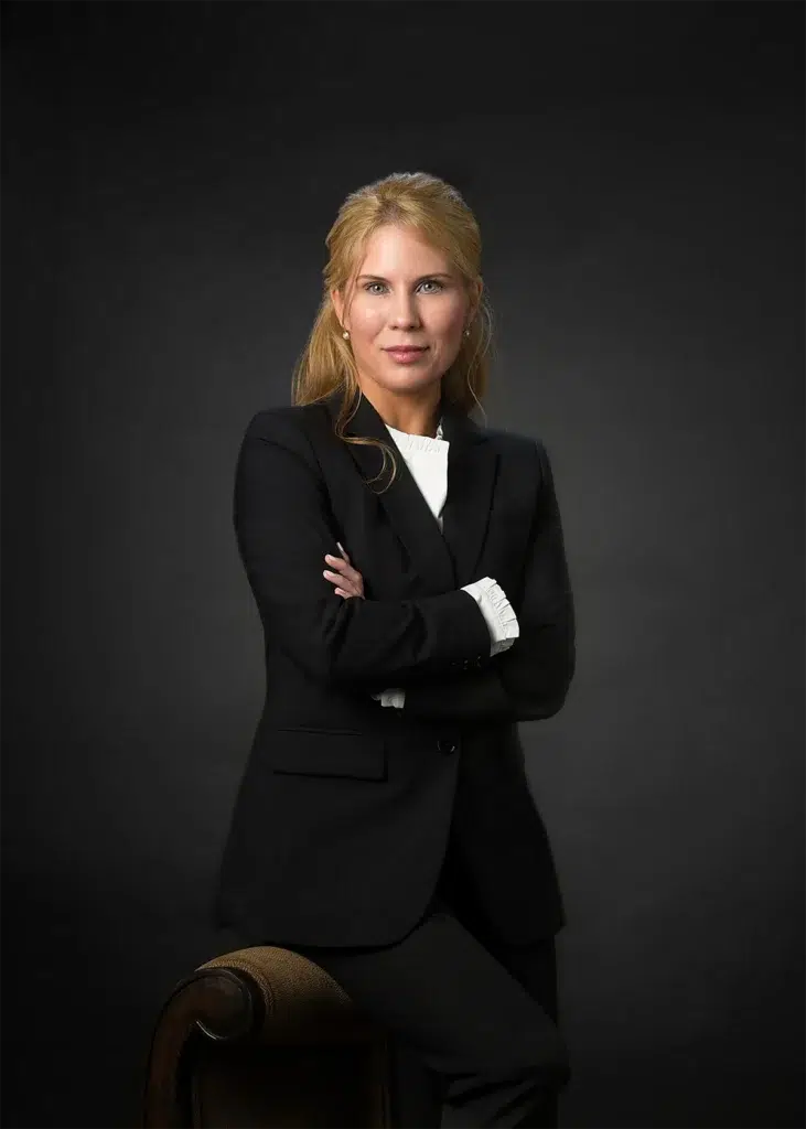 Professional executive headshot of business leader photographed with soft directional studio lighting and dark seamless background for corporate leadership profile portrait