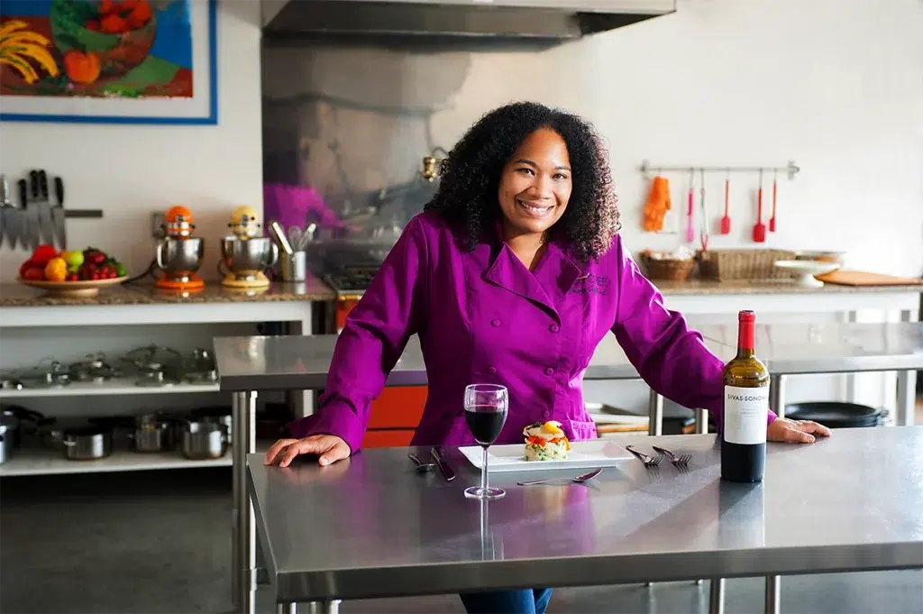 Environmental executive portrait of chef in modern culinary studio photographed with natural window lighting and shallow depth of field for hospitality branding