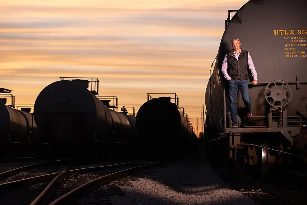 Bespoke executive portrait of business leader standing on rail tanker at sunset photographed with dramatic directional lighting and environmental composition for executive personal branding