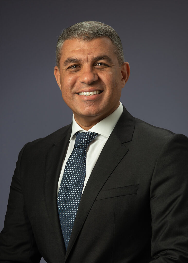 Corporate executive headshot before retouching showing natural skin texture, facial lines, and original lighting prior to professional portrait enhancement