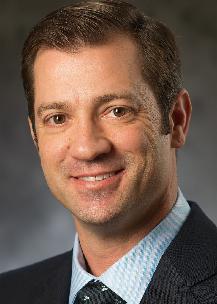 Close-up professional headshot before retouching showing natural skin texture, facial lines, and original lighting prior to portrait editing