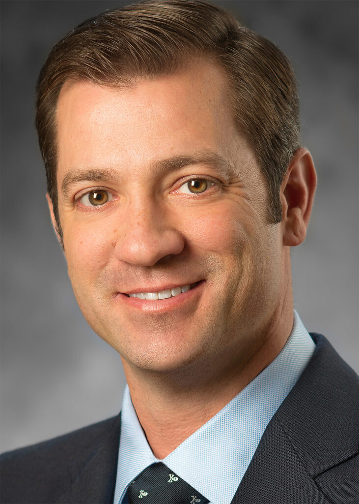 Close-up corporate headshot after professional retouching with refined skin smoothing, blemish removal, and balanced color correction for a polished portrait