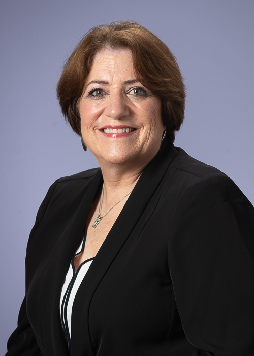 Professional corporate headshot before retouching showing natural skin texture, visible facial lines, and original studio lighting prior to retouching