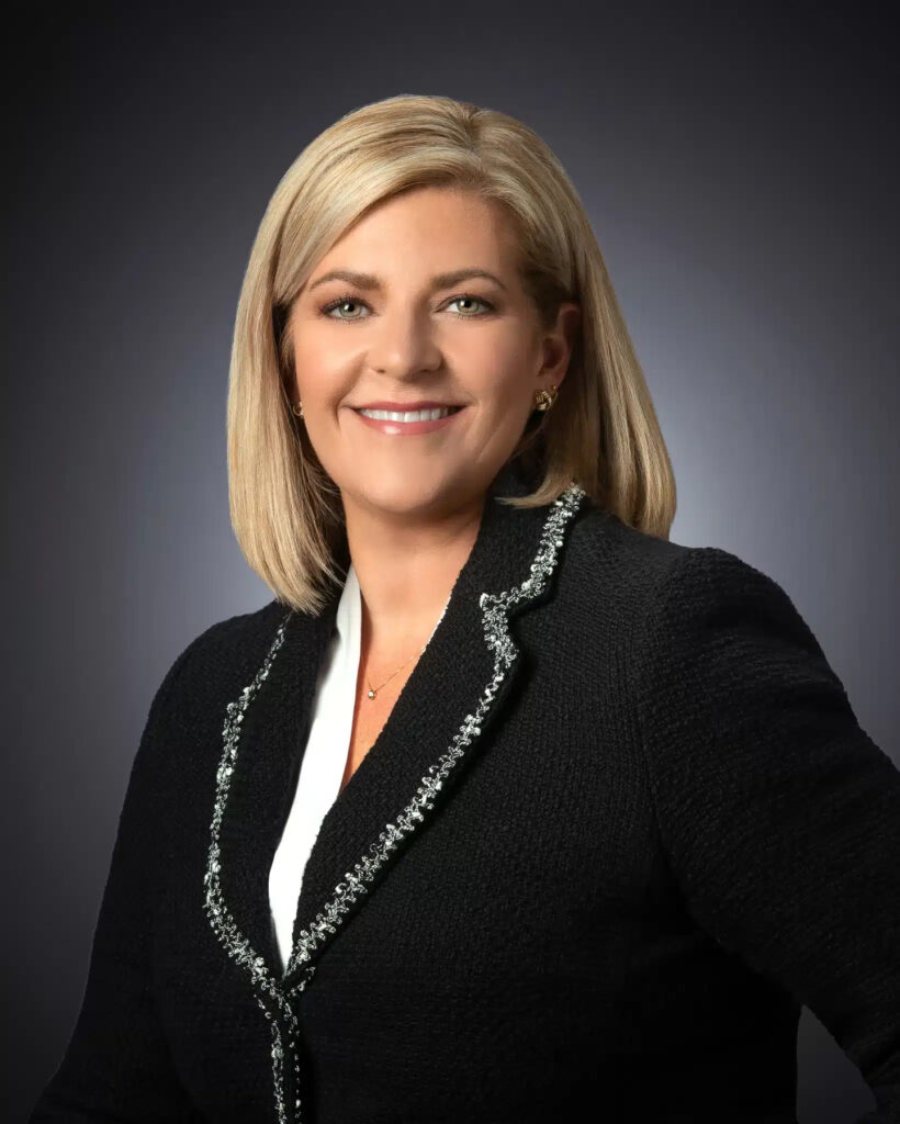 Professional studio headshot of female executive in black blazer photographed with soft studio lighting and neutral gray gradient background for corporate branding and LinkedIn profile. For Headshot Photography Portfolio