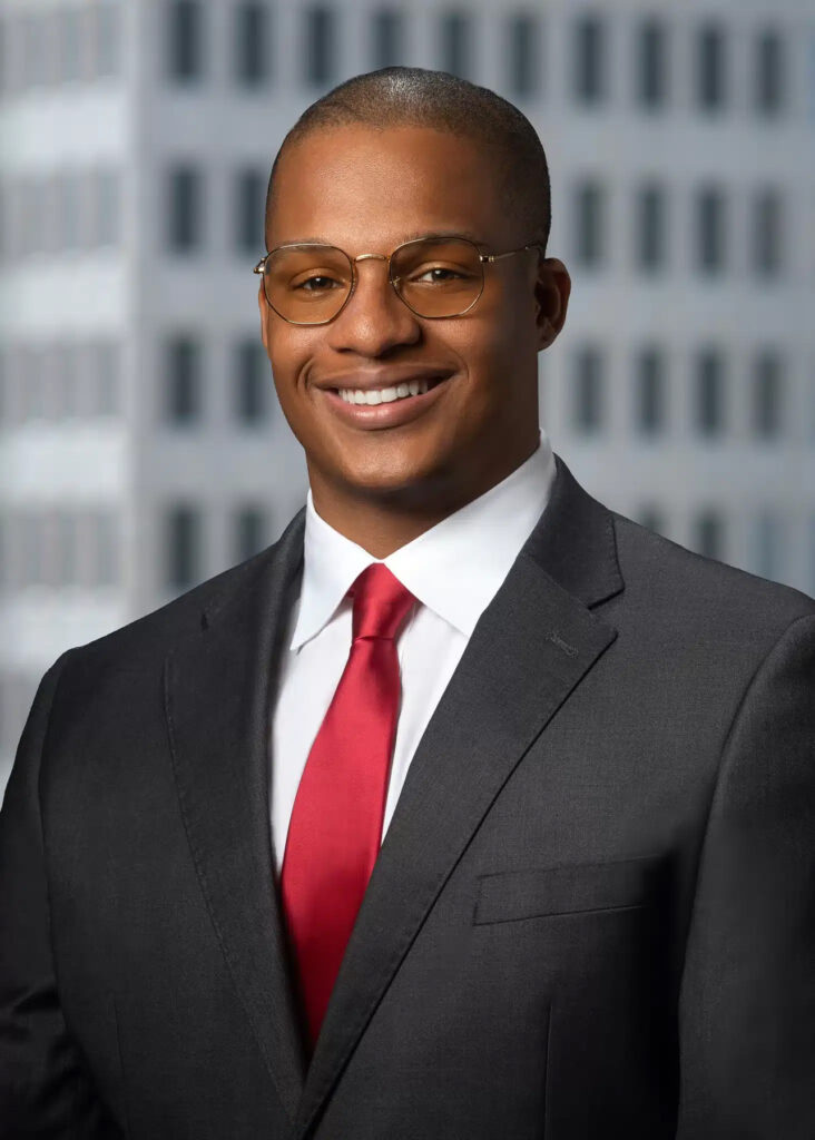 On-location corporate headshot of male executive photographed with soft natural light and modern office building background for professional business and LinkedIn branding