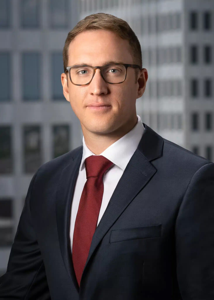 On-location corporate headshot of male executive photographed with soft natural light and modern office building background for professional business and LinkedIn branding