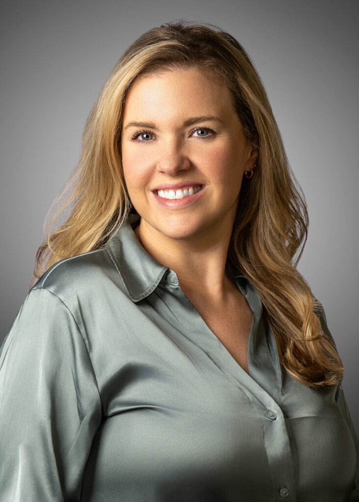 Professional studio headshot of smiling female executive photographed with soft studio lighting and neutral gray background for corporate branding and LinkedIn profile. For Headshot Photography Portfolio